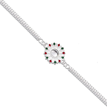 Silver Meenakari Rakhi displayed with roli chawal for Raksha Bandhan rituals.