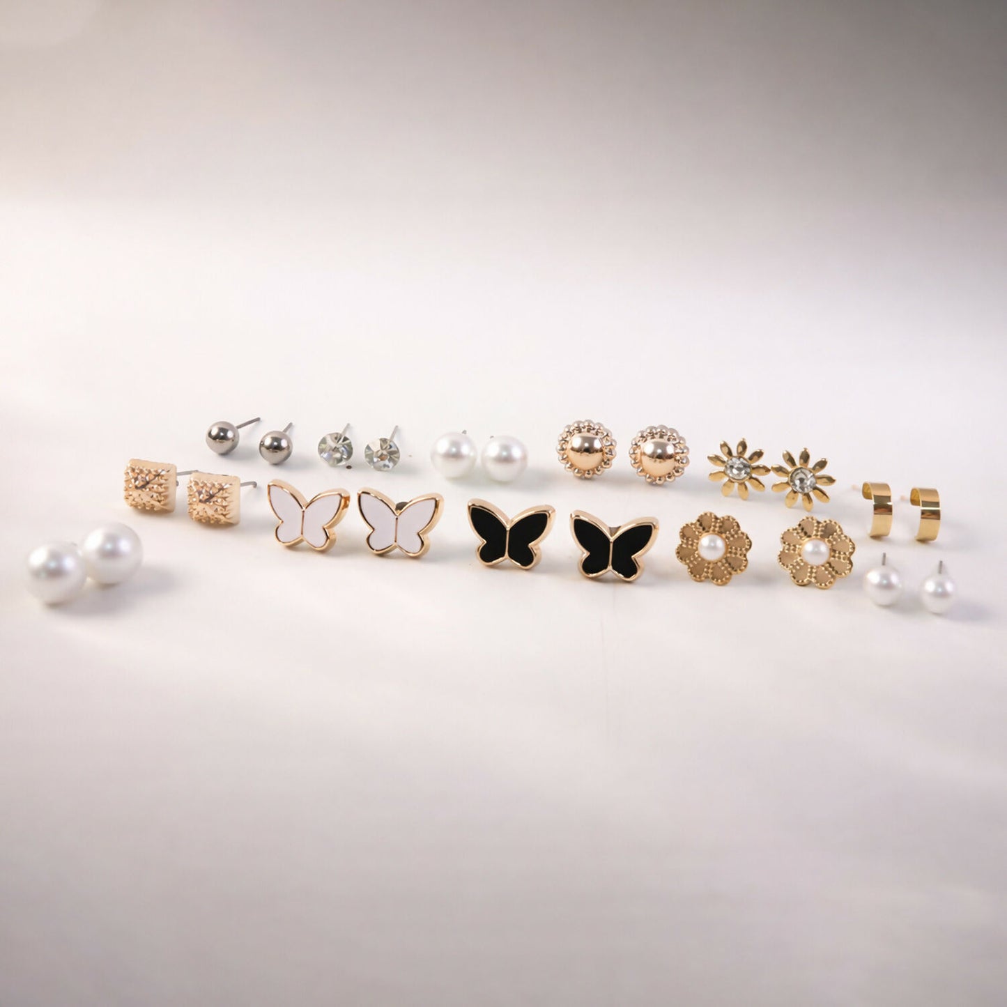Elegant pearl and butterfly charm earrings included in the 12-pair set