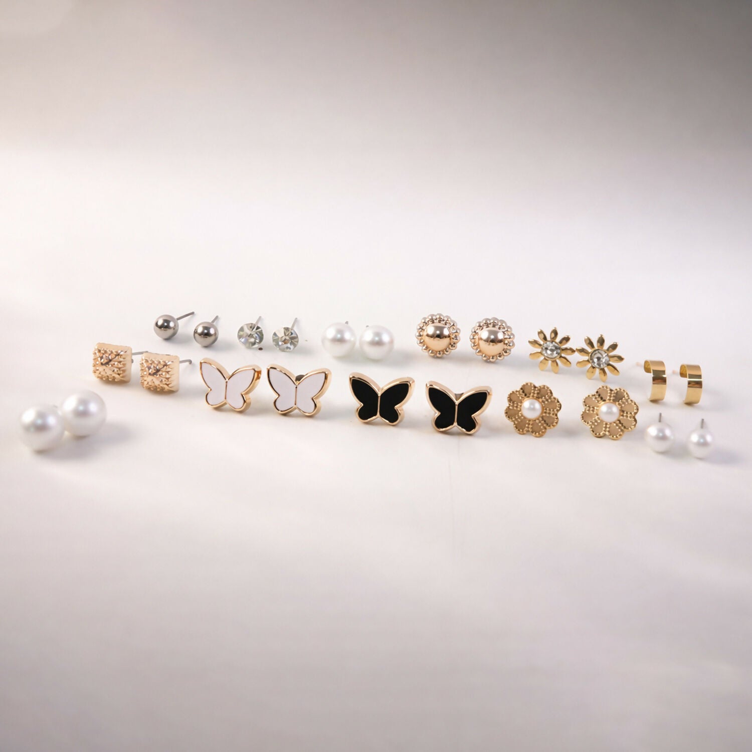Elegant pearl and butterfly charm earrings included in the 12-pair set