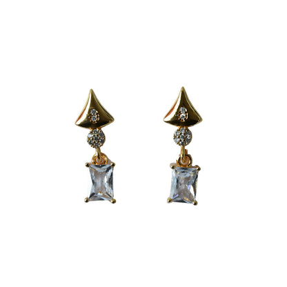 Pair of gold tone geometric crystal drop earrings laid flat showing design details