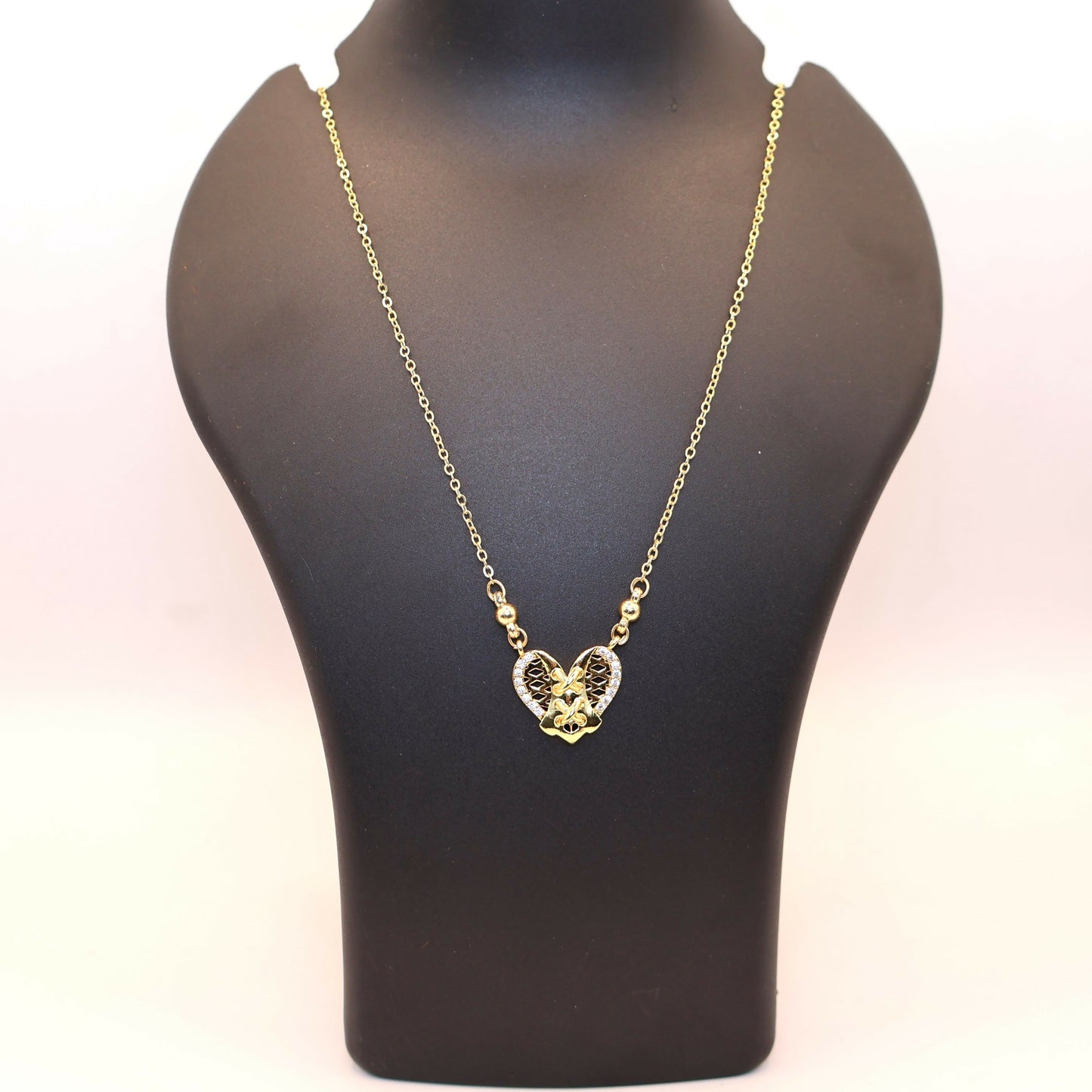 Elegant gold heart pendant necklace displayed on white background