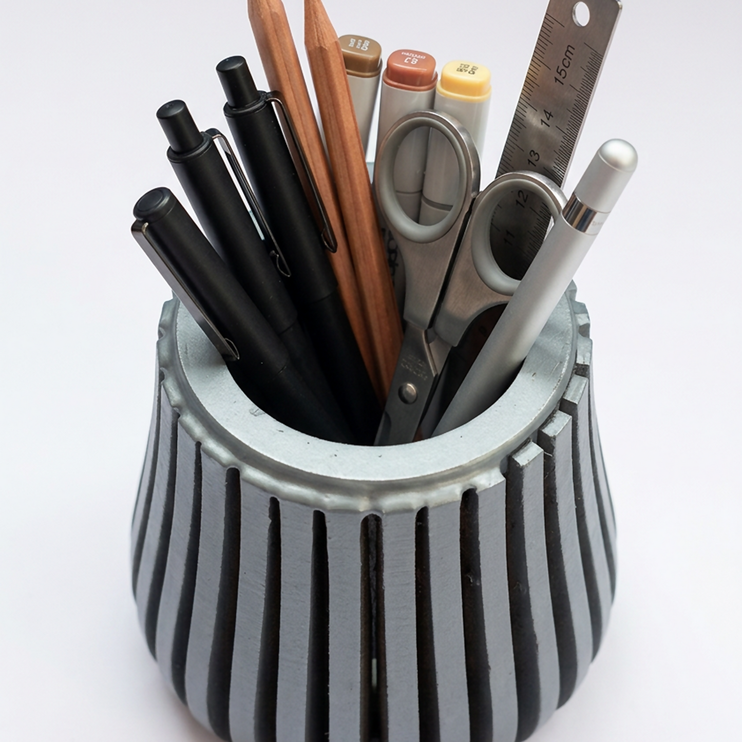 Compact wooden desk organiser filled with pens and pencils.