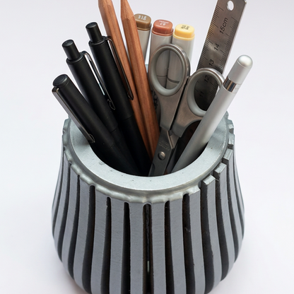 Compact wooden desk organiser filled with pens and pencils.