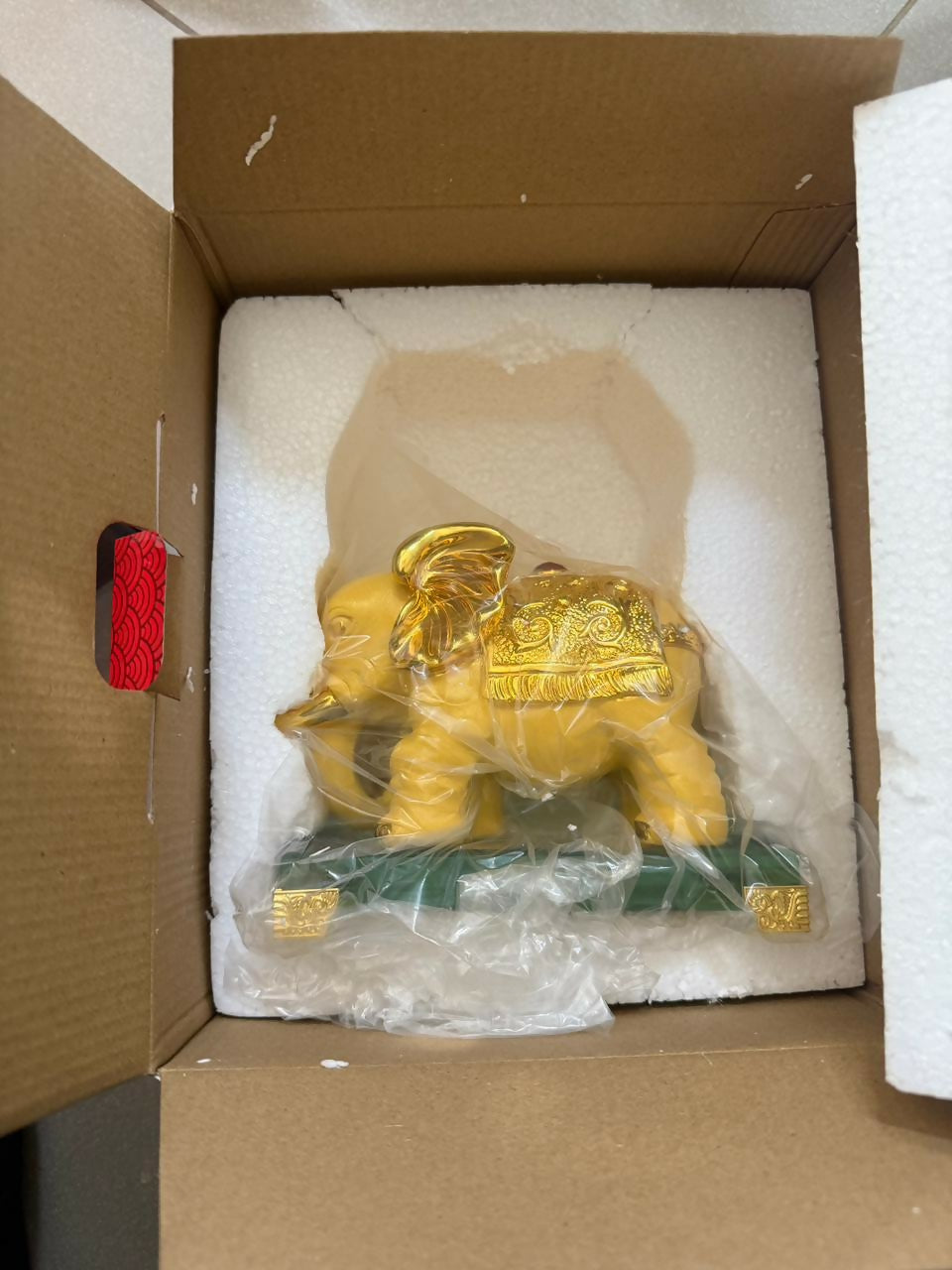 Golden elephant decor statue displayed in a home temple setting
