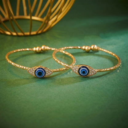 Close-up of gold evil eye bangle showing blue eye and sparkling stones