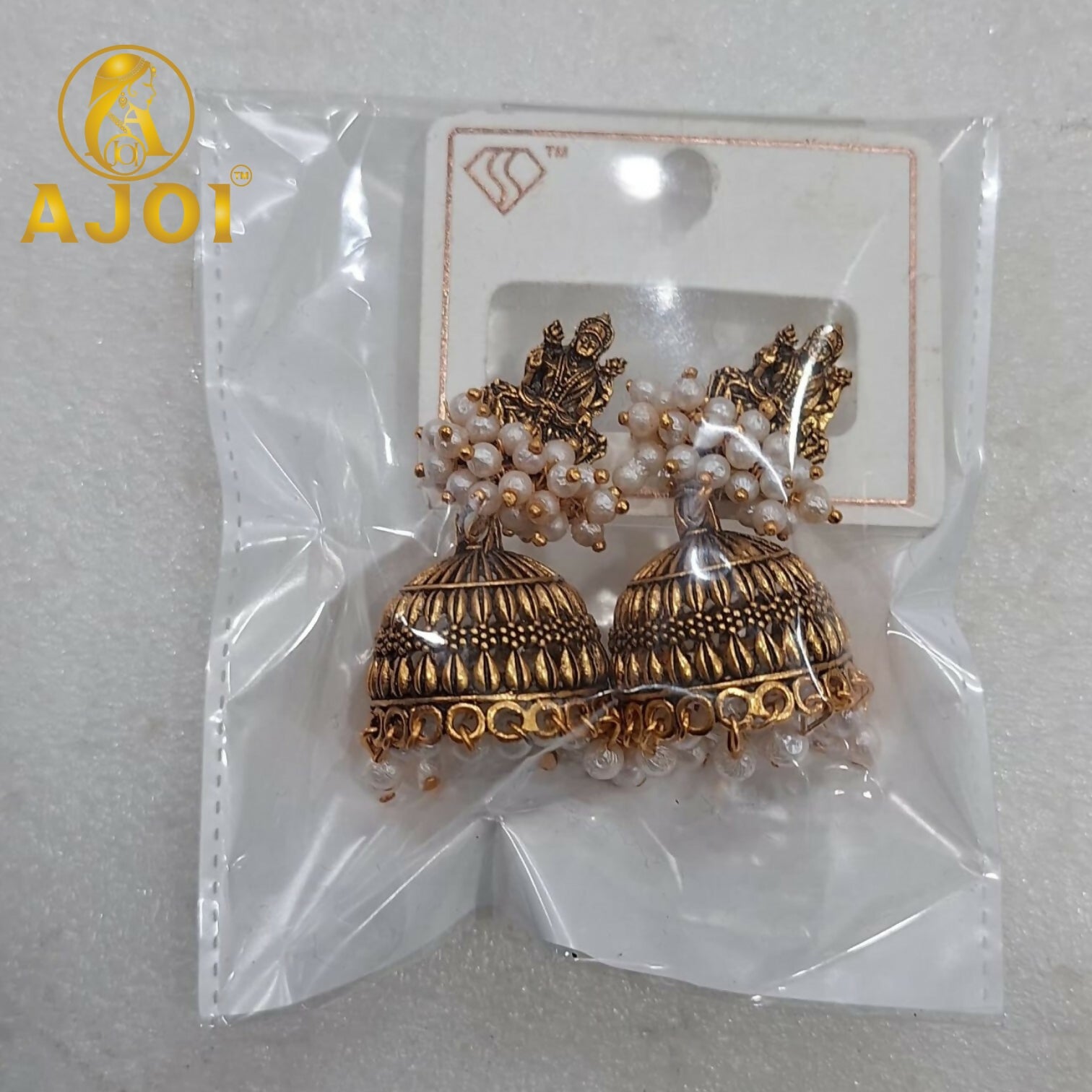 Pair of antique gold pearl jhumka earrings on white background