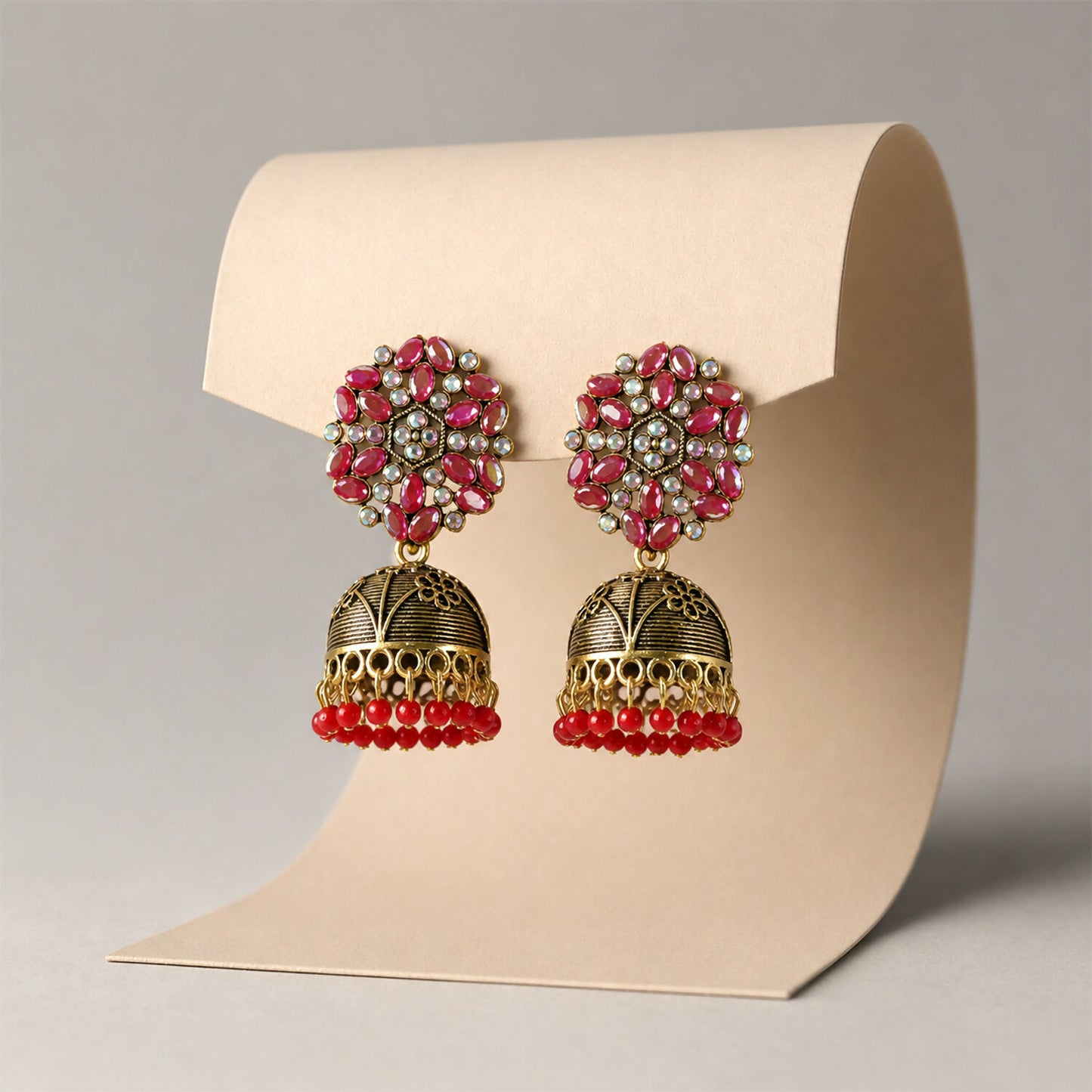 Golden jhumka earrings with red bead and floral design, front view