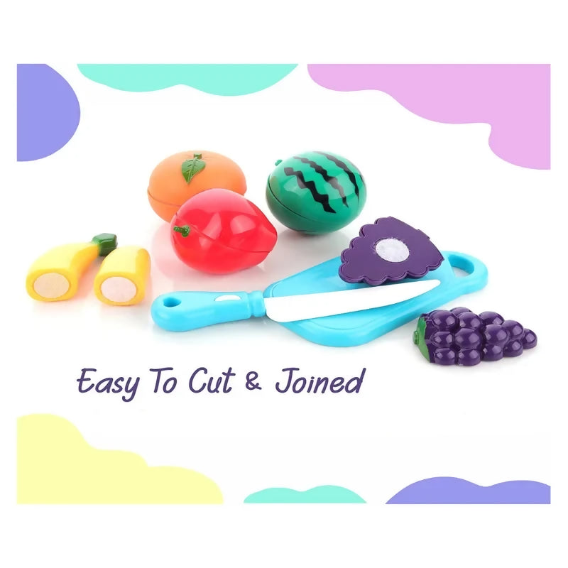 An orange, watermelon, apple, banana, purple grape cluster, and blue cutting board with a knife on a white surface.