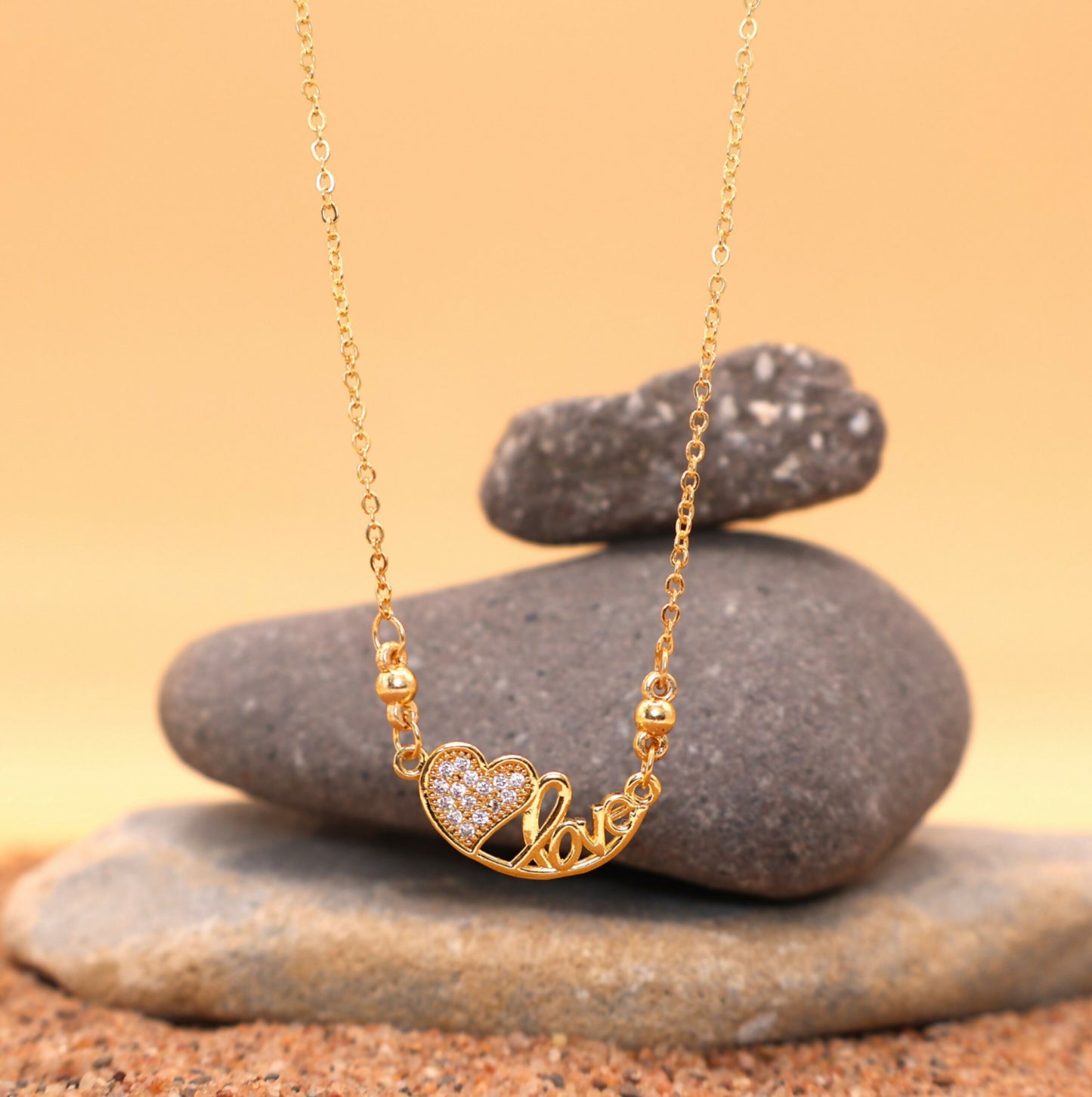 Close-up of elegant "Love" script on gold-plated pendant necklace for women and girls