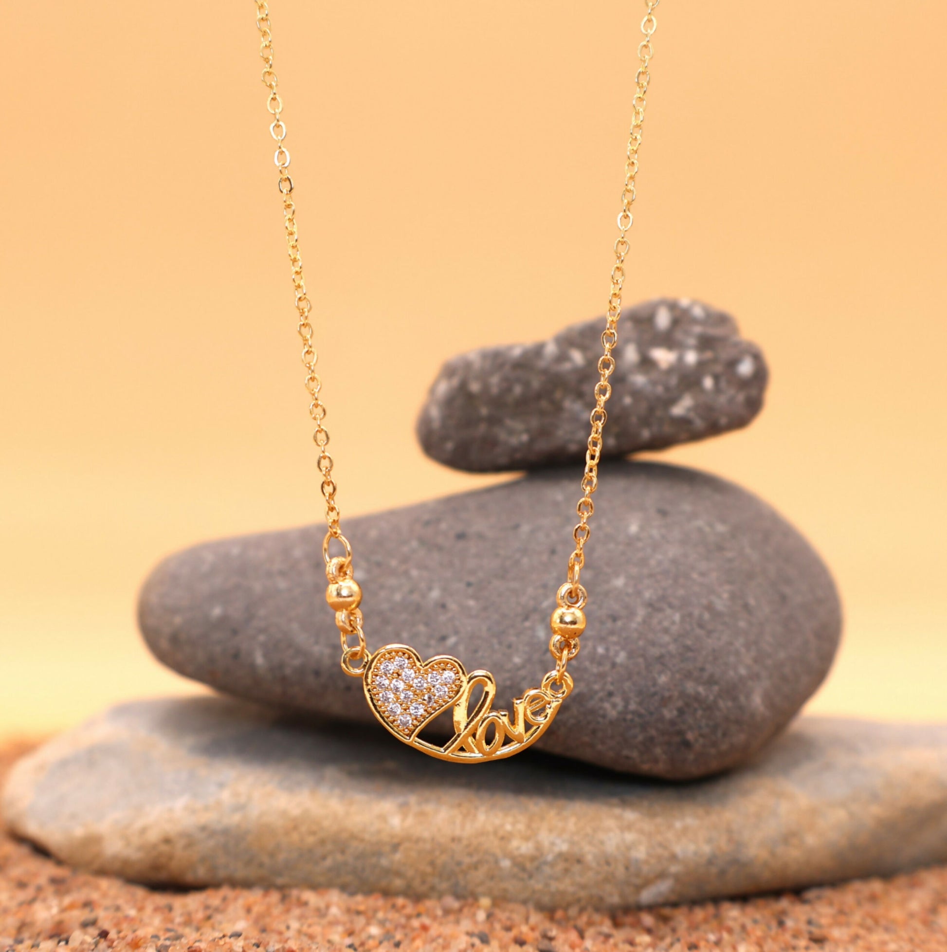 Close-up of elegant "Love" script on gold-plated pendant necklace for women and girls