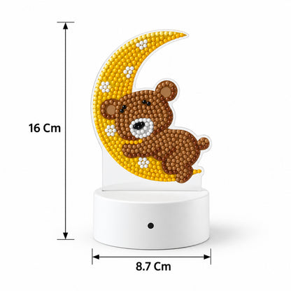 A white base with a clear acrylic panel showing a diamond painting of a teddy bear on a moon, with dimensions of 16 cm