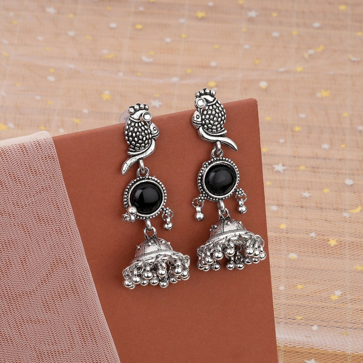 Oxidized jhumka earrings with black stone and intricate owl design, front view