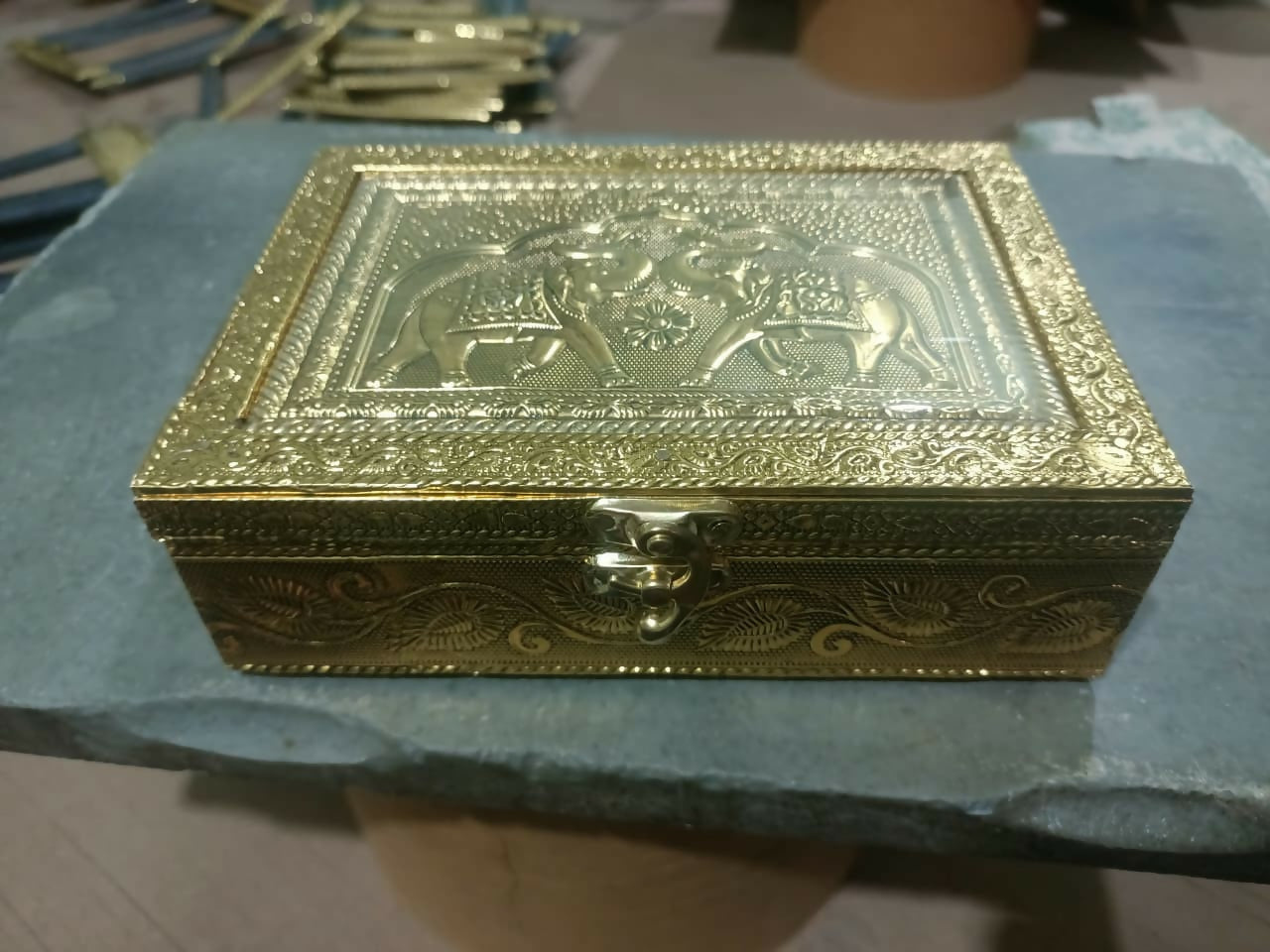 Side view of brass elephant jewelry box with embossed patterns