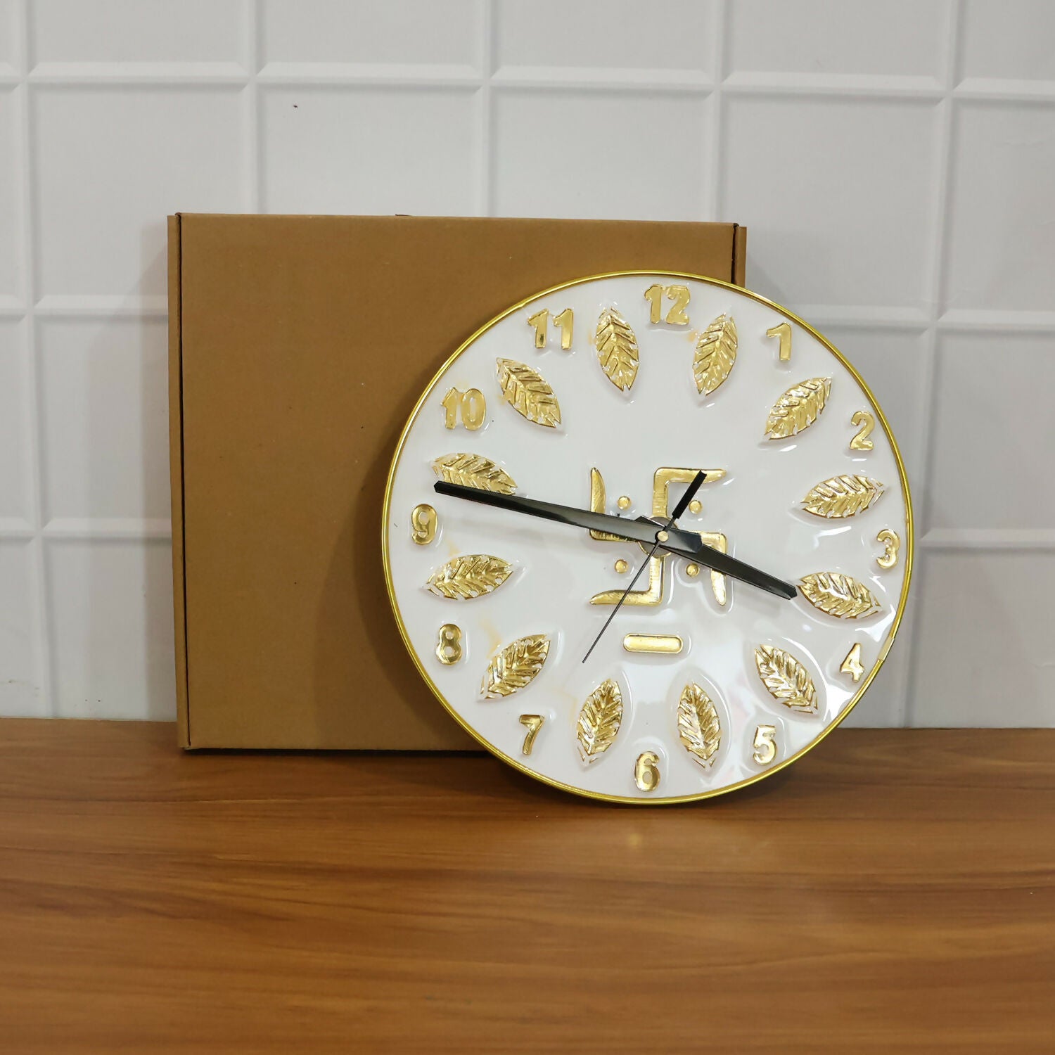 Decorative silver Swastik wall clock on a white wall background
