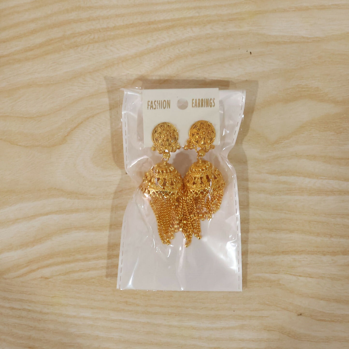 Model wearing golden long tassel jhumka earrings