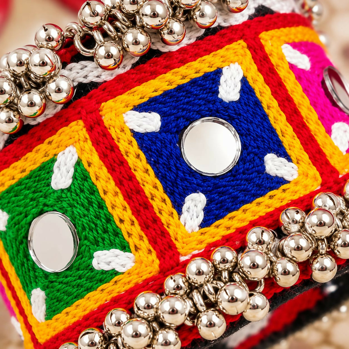 Close-up of the kada bracelet showing intricate embroidery, small mirrors, and numerous silver-tone beads.
