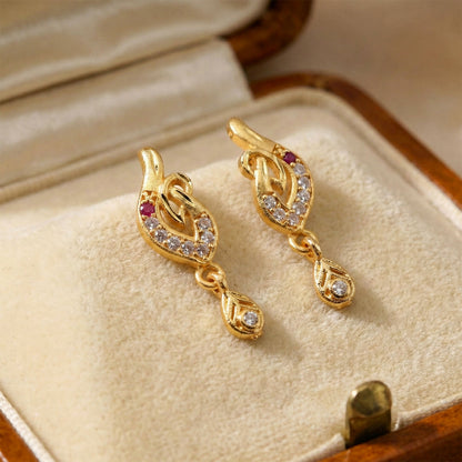 Close-up of gold leaf drop earrings showing stone detailing