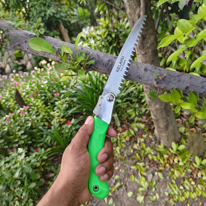 Folding saw in action cutting wood, with non-slip handle visible
