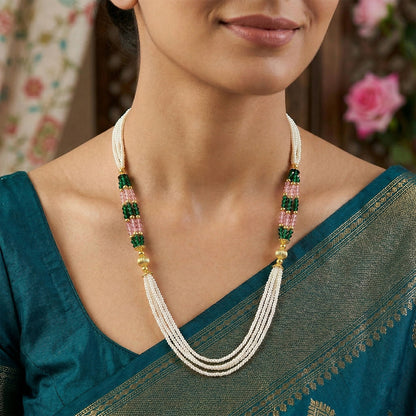 Close-up of layered pearl strands with green and pink bead accents