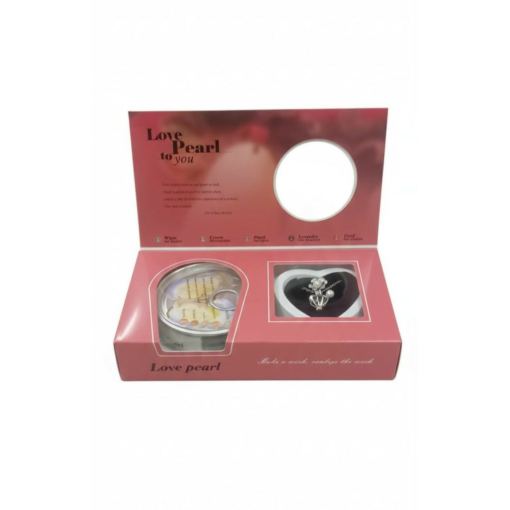 A pink gift box with an open lid displays a pearl pendant and a sealed oyster can.