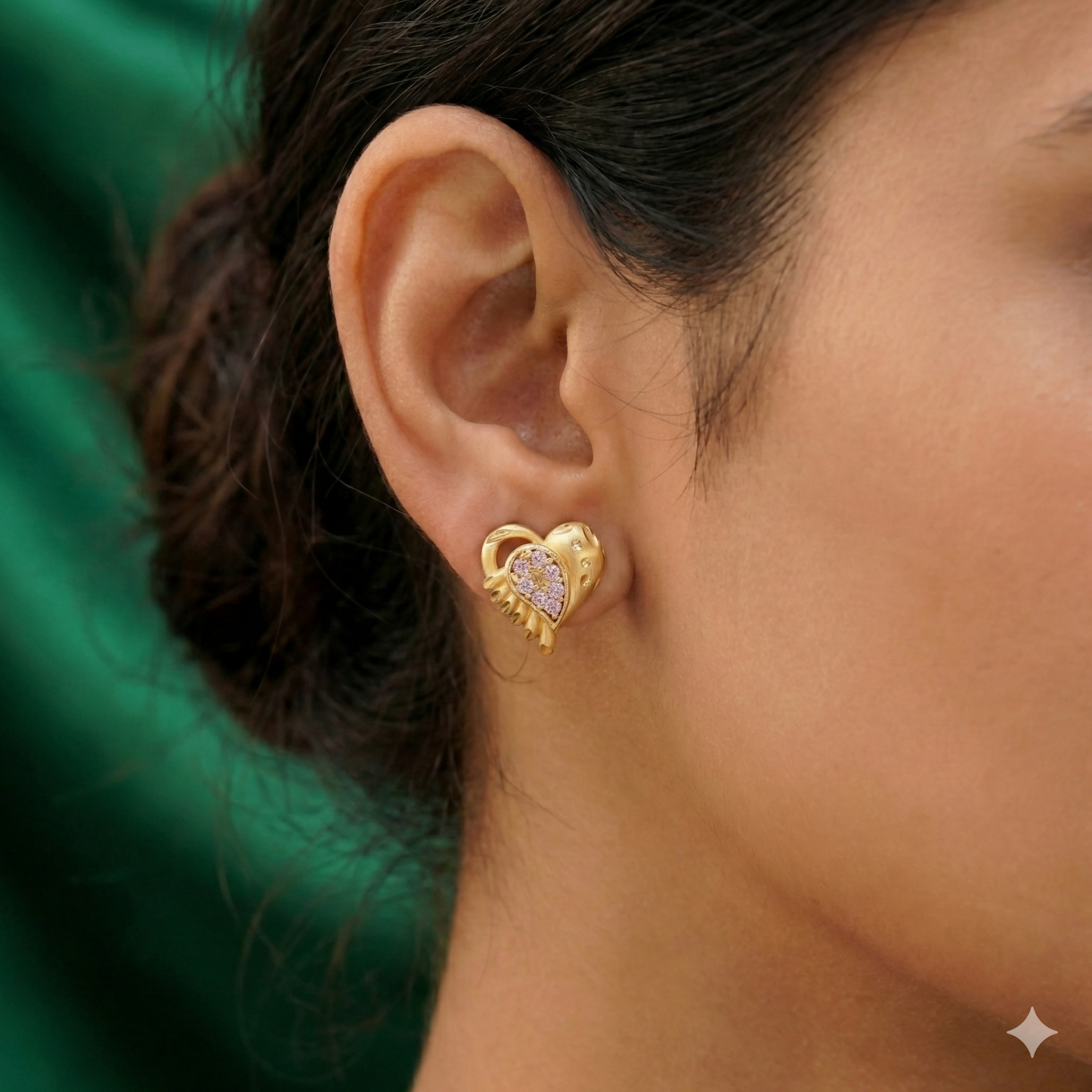 Close-up of gold heart stud earrings featuring sparkling white micro-pavé crystals and scalloped edges