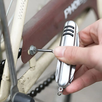 The silver 5-in-1 multi-tool is displayed with its knife, bottle opener, corkscrew, and awl extended.