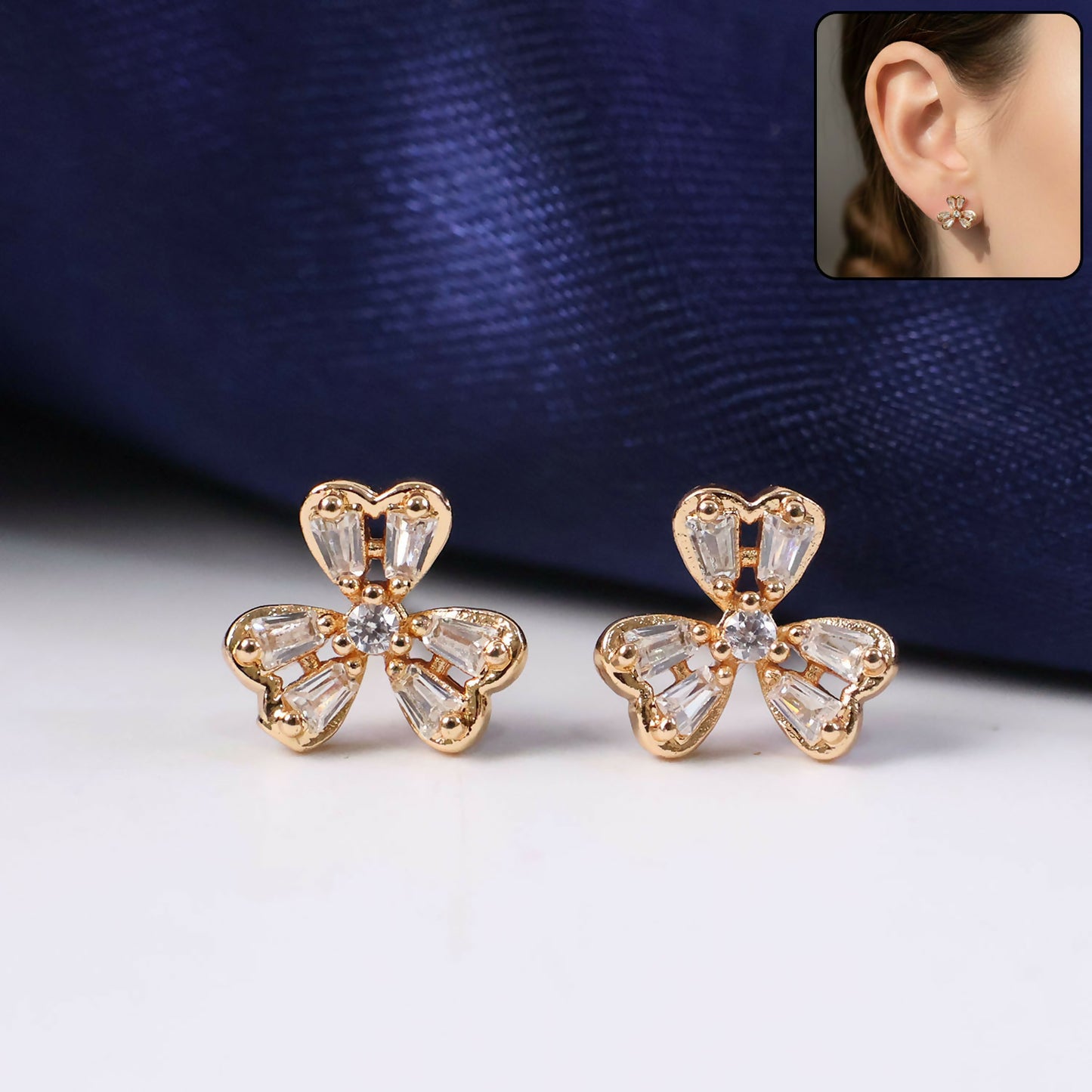 Close-up view of floral stud earrings embellished with sparkling CZ stones and gold-tone finish