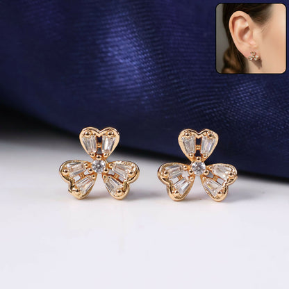 Close-up view of floral stud earrings embellished with sparkling CZ stones and gold-tone finish