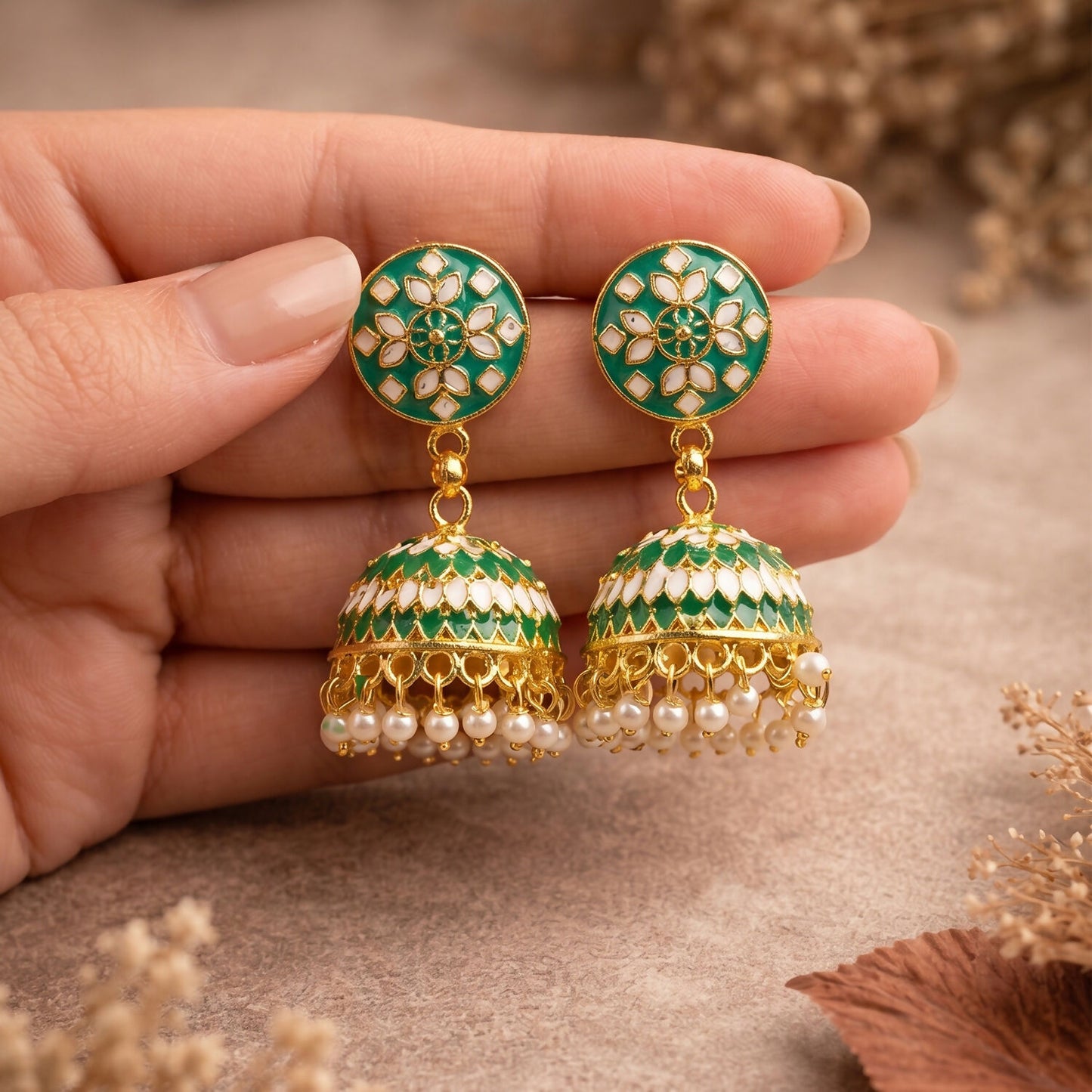 Detailed view of pearl hanging on green floral jhumka earrings