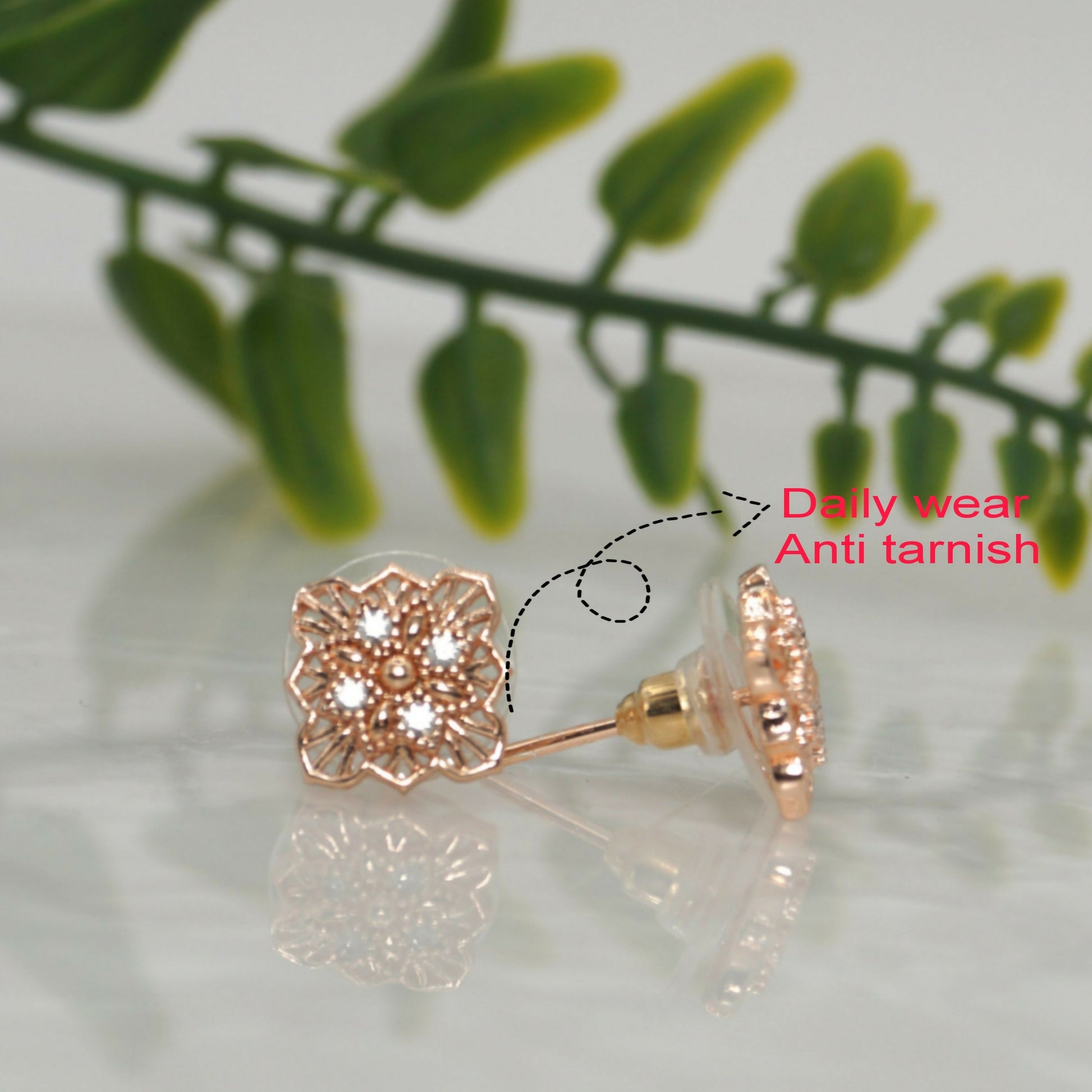 Close-up of sparkling AD stones in rose gold filigree square stud earrings