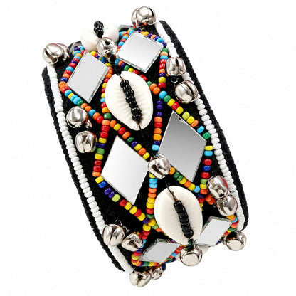 A wide black cuff bracelet with colorful beads, mirrors, shells, and silver bells on a white background.