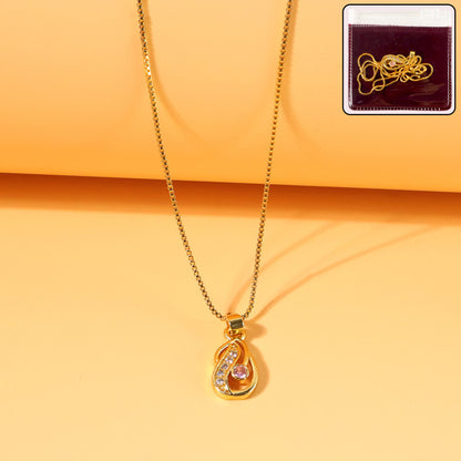 Close-up of gold-plated tear-drop pendant necklace featuring pink stone and crystals