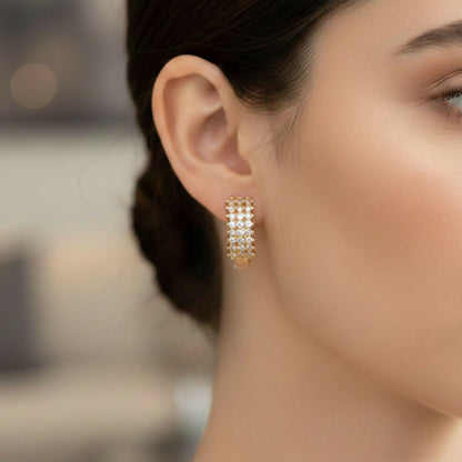 Close-up of cubic zirconia stones studded on gold-tone hoop earrings