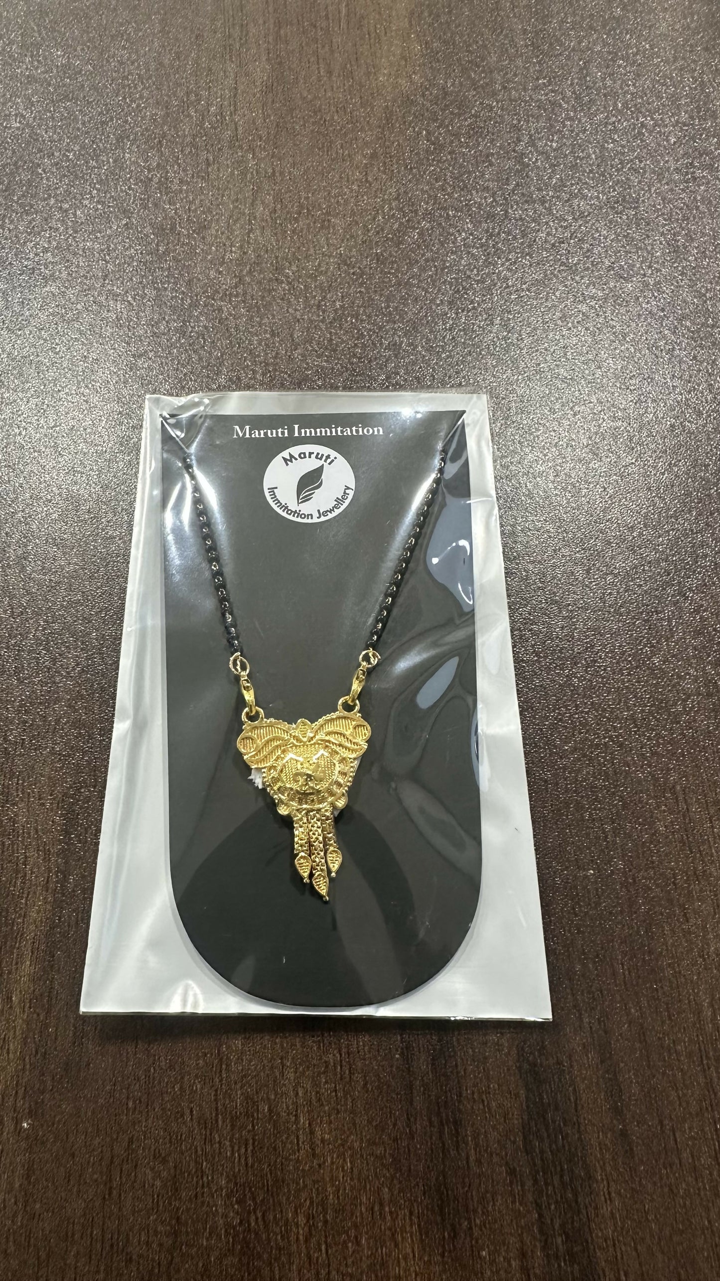 CZ-studded heart with a couple silhouette, this pendant is cast in gold-toned imitation metal to celebrate the sacred bond of marriage.