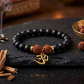 Sacred Om Charm Rudraksha Bracelet with Matte Black Beads and Golden Accents