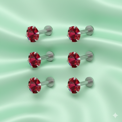 Close-up view of a red crystal labret nosepin stud highlighting the crystal sparkle