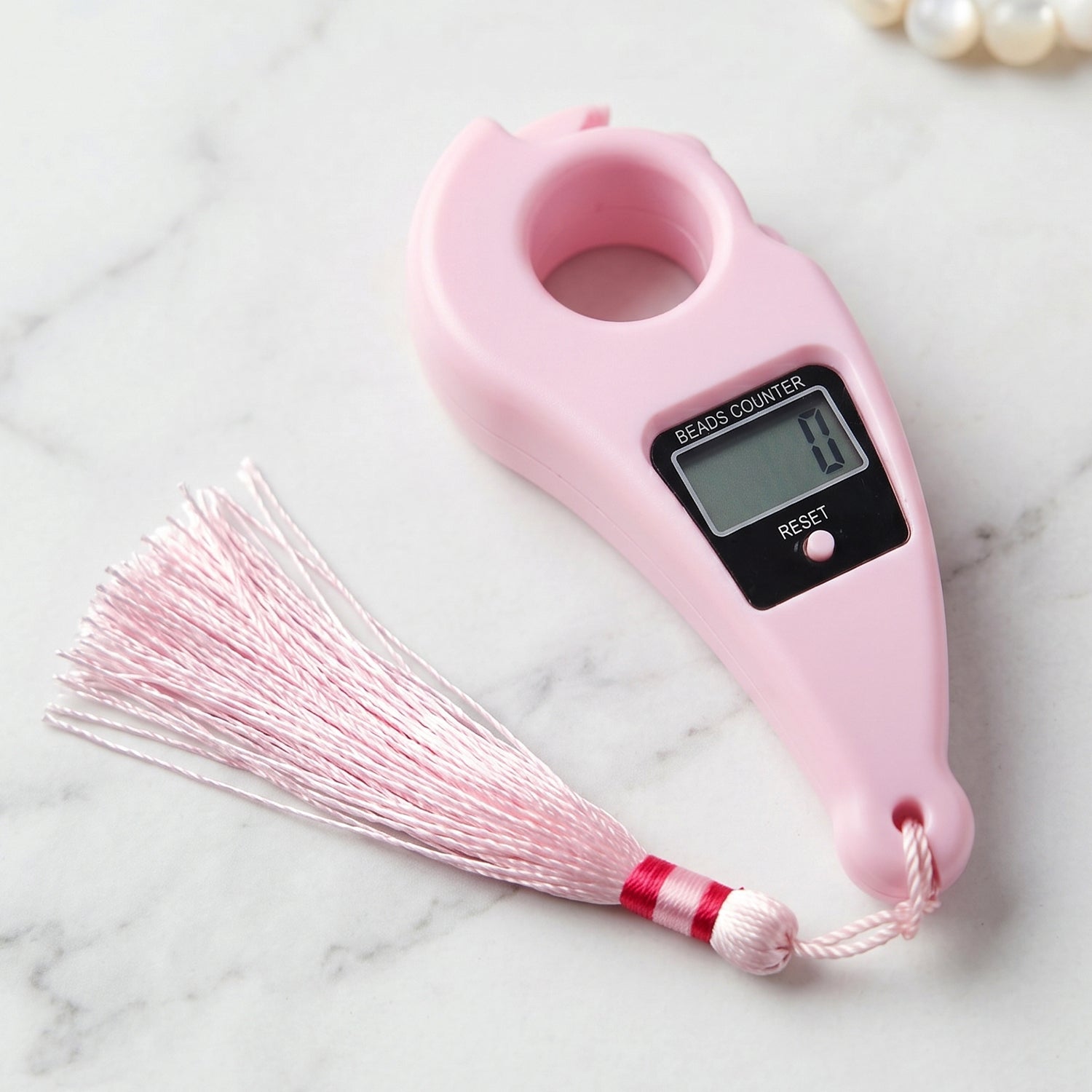 Close-up of pink digital mantra jaap counter with button and LCD screen