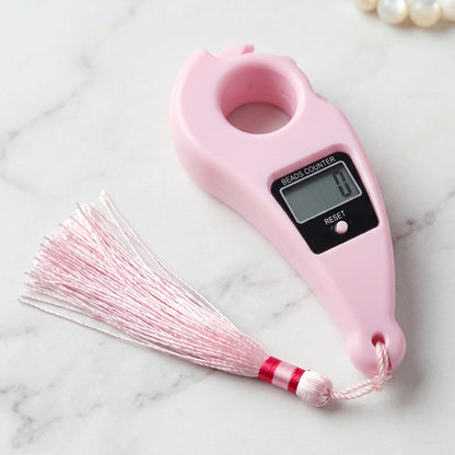 Close-up of pink digital mantra jaap counter with button and LCD screen