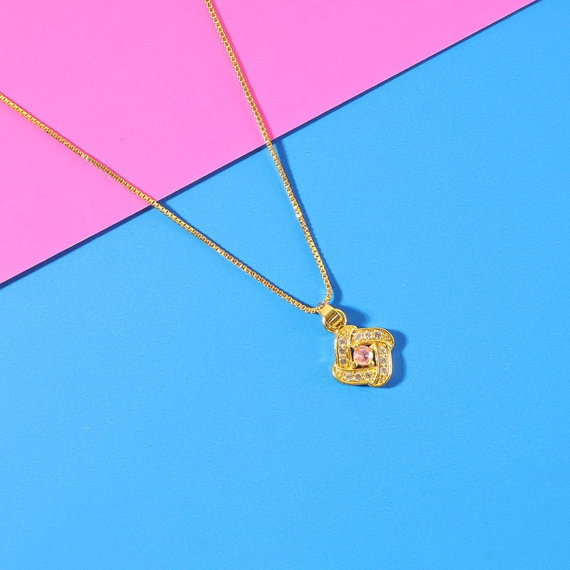 Close-up of golden square charm pendant necklace with pink stone accent
