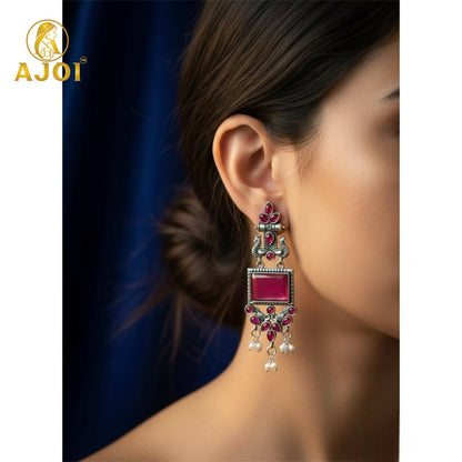 Close-up of pink square beads in antique silver earrings