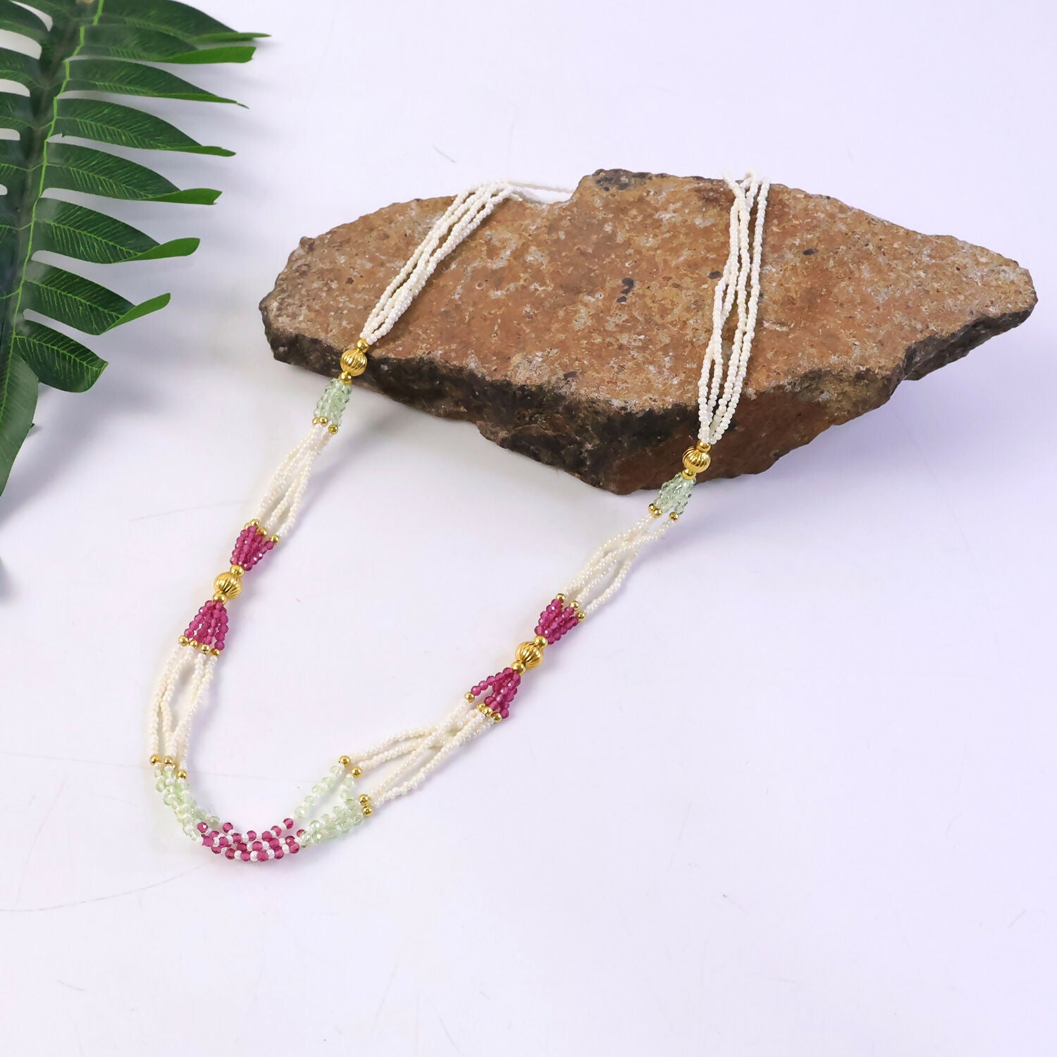 Detail shot of pink and mint accent beads on pearl mala necklace