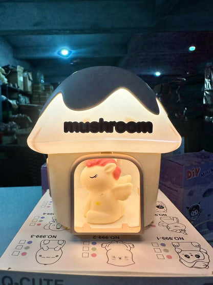 Mushroom house night light with a unicorn figurine glowing brightly, sitting on a patterned box in a dimly lit room.