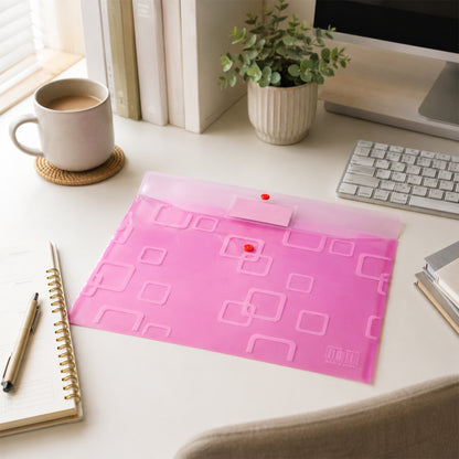 A closed pink plastic document folder on a white desk with a mug, plant, keyboard, and notebook.