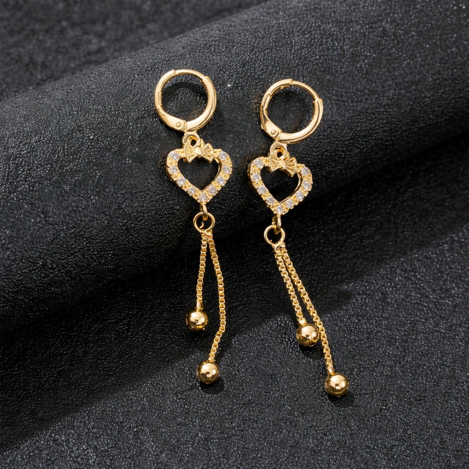 Heart shape drop earrings with sparkling stones and gold-finish chain tassels