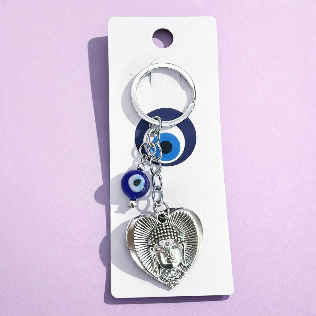 Close-up of Buddha heart pendant with evil eye bead on keychain
