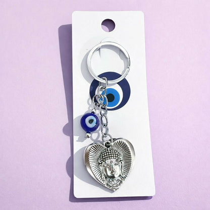 Close-up of Buddha heart pendant with evil eye bead on keychain