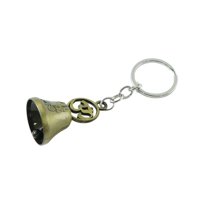 Om temple bell keychain displayed on a textured surface