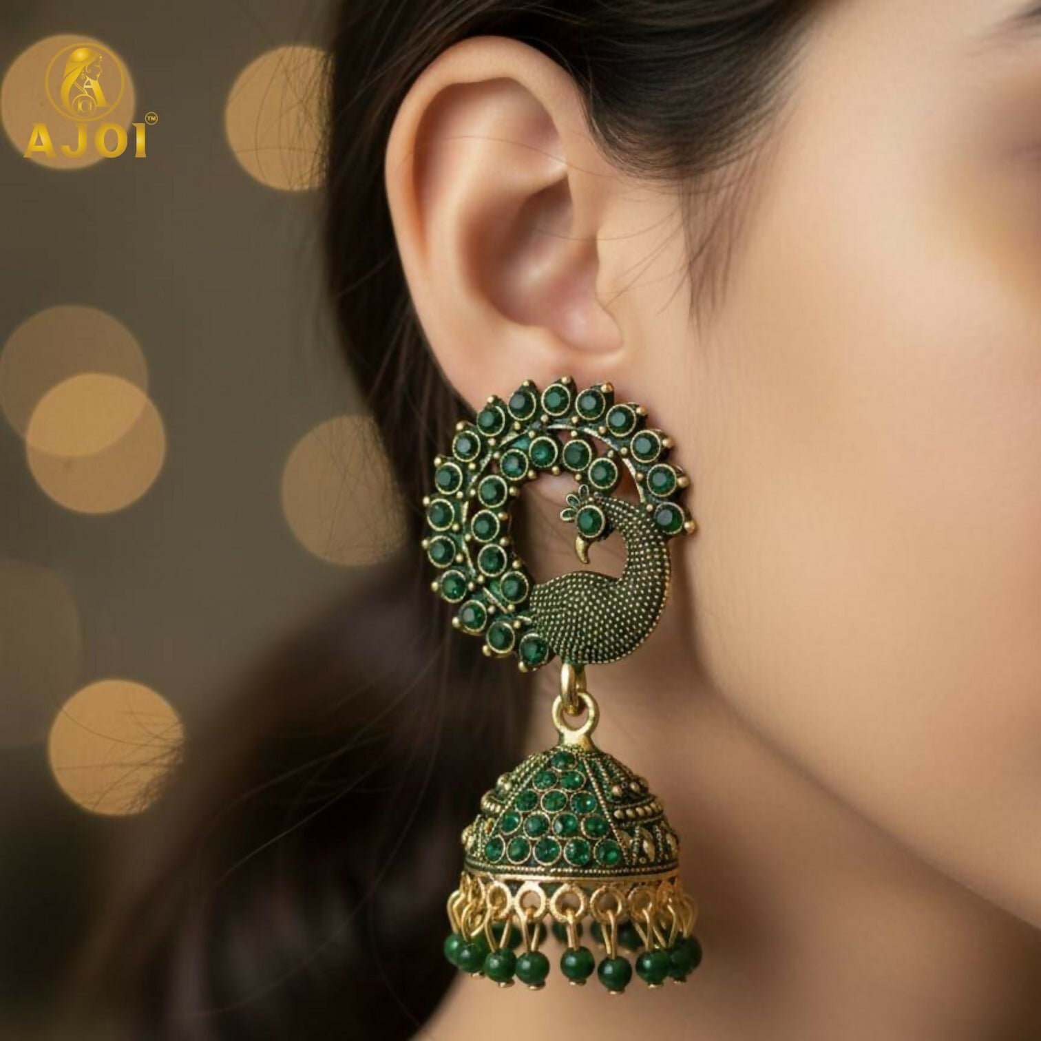 Close-up of intricate green stone & antique gold peacock jhumka