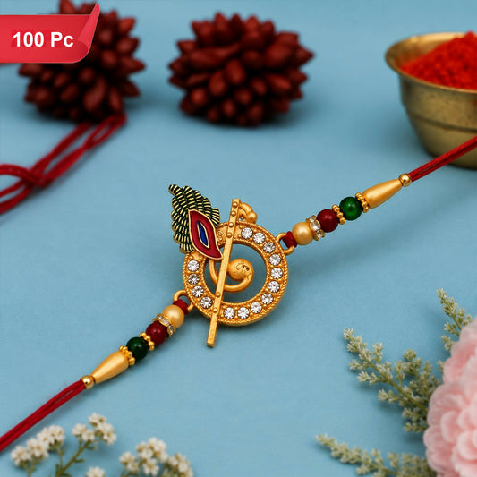 A gold-toned Lord Krishna motif with a flute and peacock feather, adorned with clear stones, on a red thread with green and