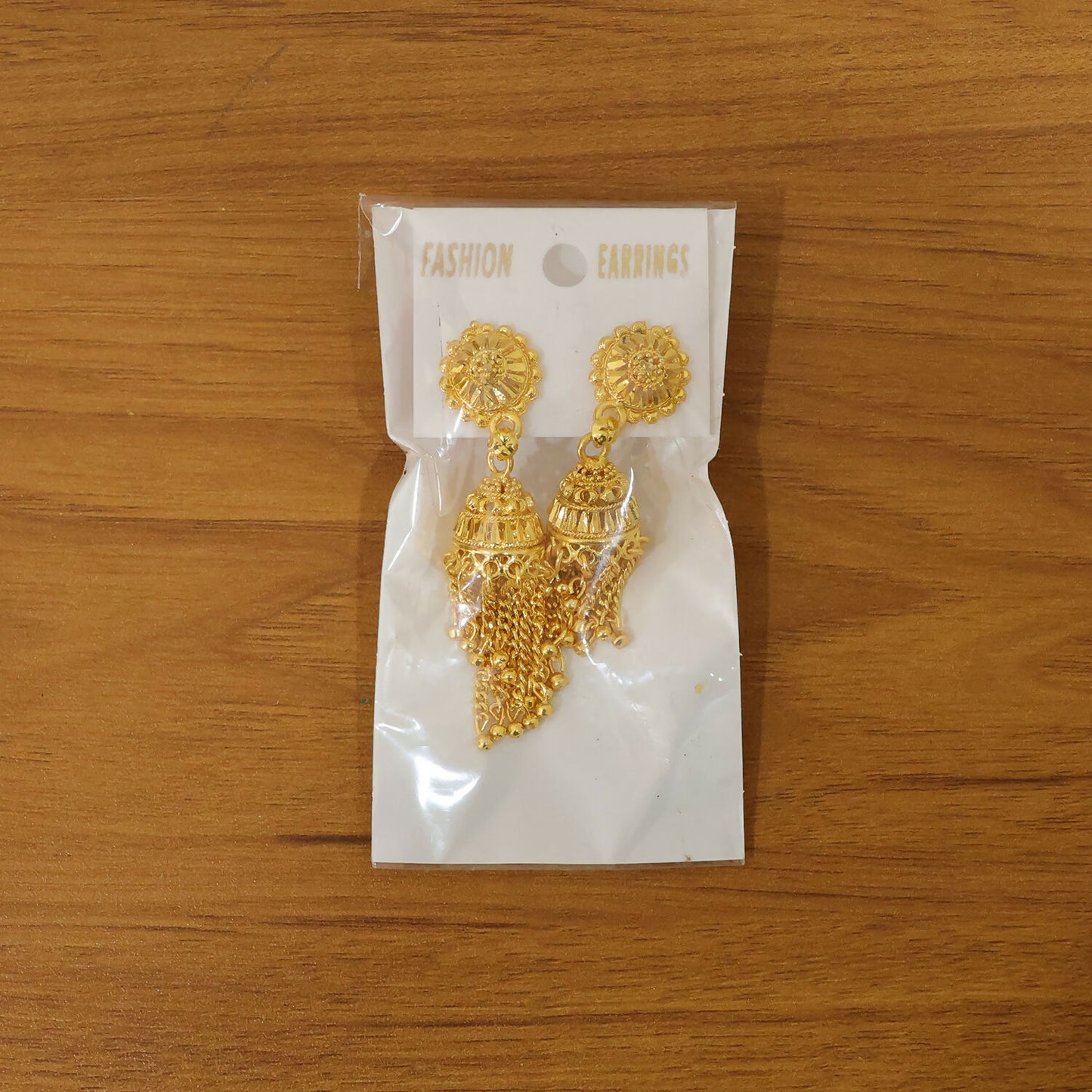 Gold plated tassel jhumka earrings showcased as party wear accessory
